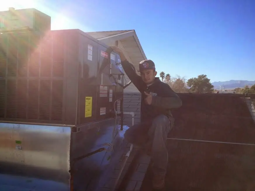 HVAC technician performing Air Duct Repair on a rooftop unit in Page